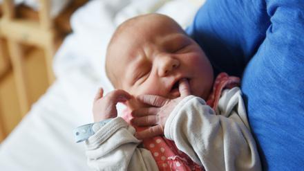 Ein Neugeborenes auf dem Arm.