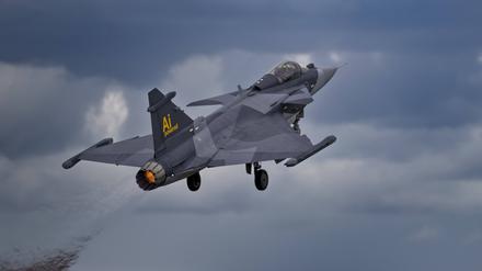 Ein Kampfflugzeug des Typs Gripen E fliegt vor Wolken (Archivbild).