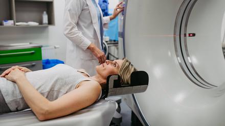 Eine Ärztin bereitet eine Frau für die Untersuchung im Computertomografen vor. (Symbolbild)