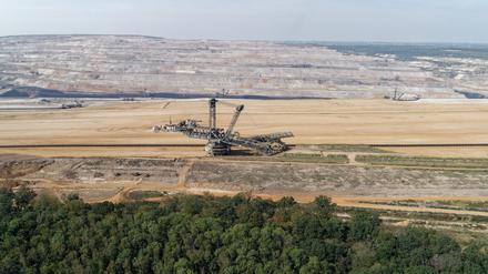 ARCHIV - 30.08.2019, Nordrhein-Westfalen, Morschenich: Ein Braunkohlebagger steht im Tagebau Hambach (Luftaufnahme mit einer Drohne). Im Vordergrund ist der Hambacher Wald zu sehen. (zu dpa: «Aktivisten besetzen Braunkohlebagger im Tagebau Hambach») Foto: Henning Kaiser/dpa +++ dpa-Bildfunk +++