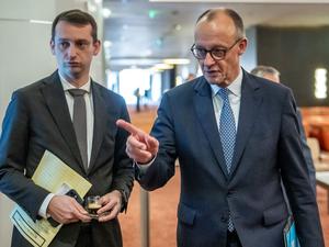 24.11.2025, Angola, Luanda: Bundeskanzler Friedrich Merz (CDU) kommt neben seinem Büroleiter Jakob Schrot (l) zu einem Treffen mit António Costa, Präsident des Europäischen Rates, vor dem EU-Afrika-Gipfel in Angola.