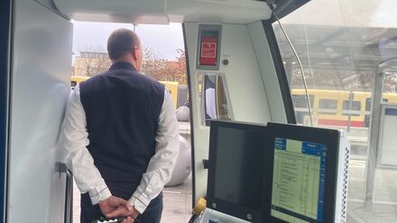 Stefan Lemke macht per Mikrofon eine Ansage, während die Fahrgäste einsteigen.