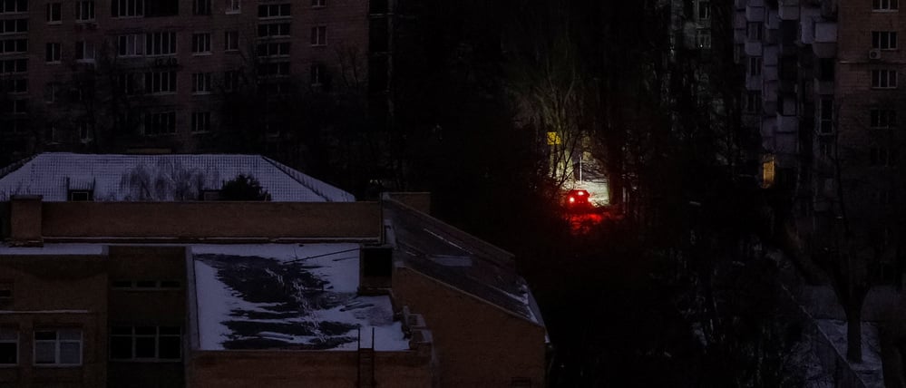 Ein Auto fährt während eines Stromausfalls auf einer Straße in Kew, nachdem wichtige zivile Infrastruktur durch die jüngsten russischen Raketen- und Drohnenangriffe getroffen wurde.