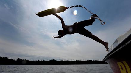 Ein Rettungsschwimmer springt während einer Rettungsübung der DLRG vom Boot in einen Badesee. (zu "Berliner Rettungsschwimmern suchen nach jungen Lebensrettern") +++ dpa-Bildfunk +++