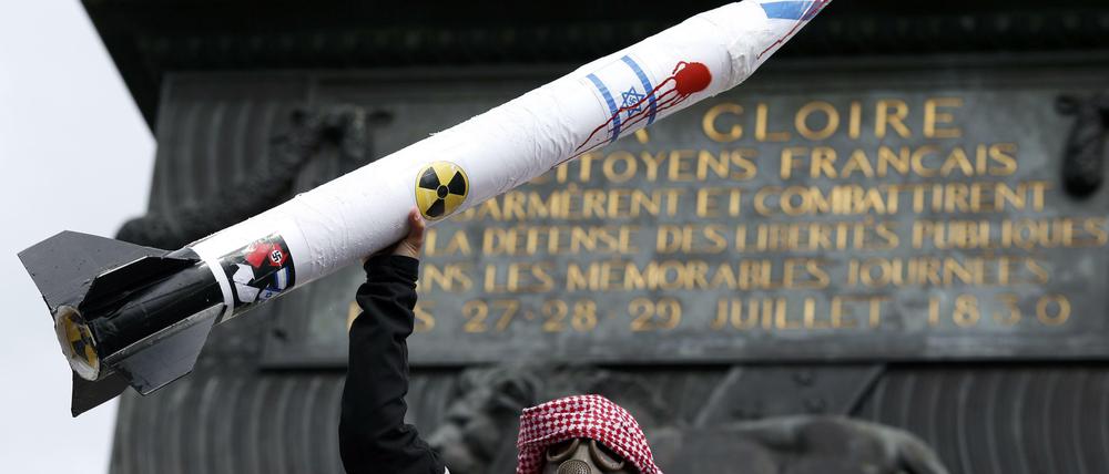 Ein Demonstrant hält eine Rakete mit israelischer Flagge in die Luft.