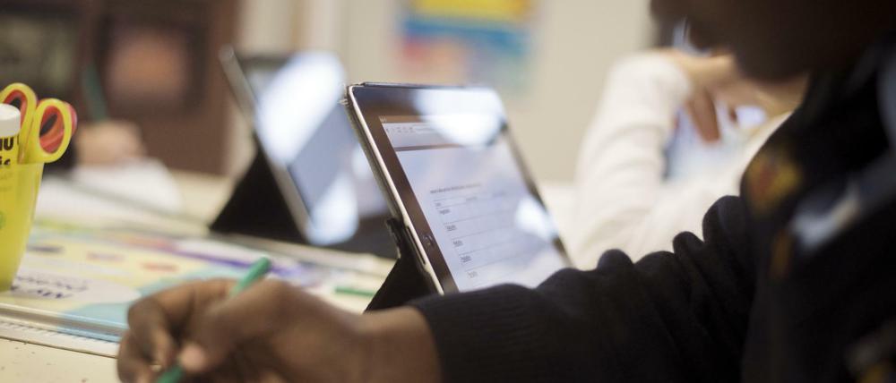 Schüler sitzen vor Tablet-Computern.