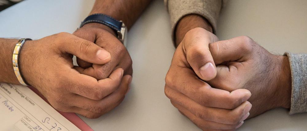 Ein Flüchtling und sein Übersetzer sitzen beim Stuttgarter Verein Arbeitsgemeinschaft Dritte Welt, der freiwillige Rückkehrer berät.