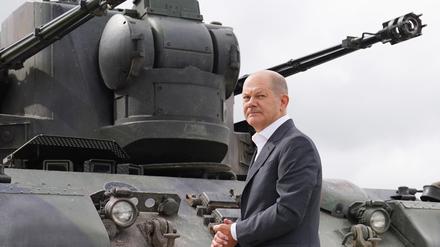 Bundeskanzler Olaf Scholz auf dem Truppenübungsplatz Putlos in Schleswig-Holstein neben einem Gepard-Panzer. 