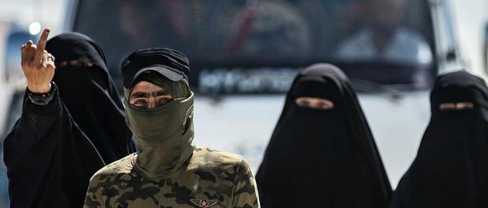 Ein Wachmann der kurdisch-assyrisch-arabischen Verwaltung in Nordsyrien führt IS-Frauen durch ein Gefangenencamp.