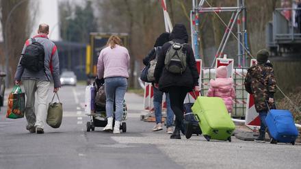 Ukrainische Flüchtlinge verlassen mit ihrem Gepäck die Flüchtlingsunterkunft im ehemaligen Fegro Großmarkt im Stadtteil Harburg.