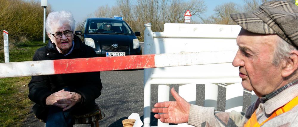 Karsten Tüchsen Hansen (rechts) und die Dänin Inga Rasmussen sitzen am deutsch-dänischen Grenzübergang.