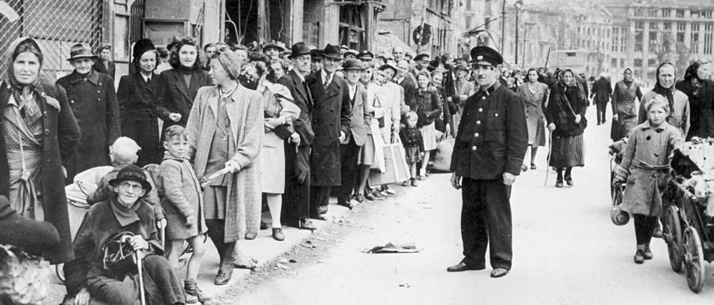 Schlange stehen nach Lebensmitteln, Alltag in der zerbombten Stadt.