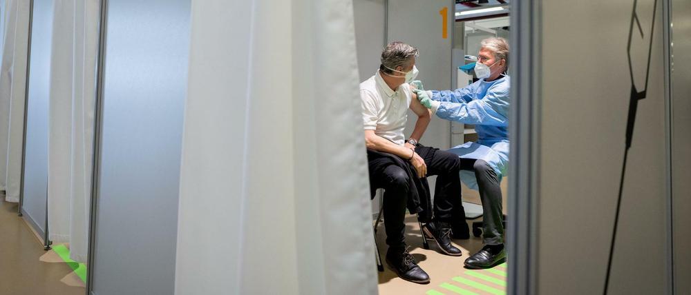 Ein Arzt bereitet im Impfzentrum in Berlin am Flughafen Tegel die Impfung eines Patienten mit dem Impfstoff von AstraZeneca vor.