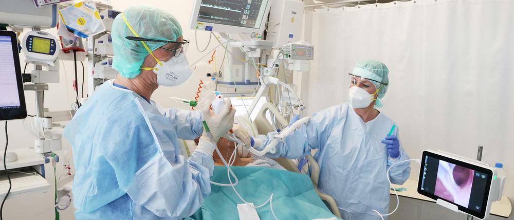 Ärzte und Pfleger untersuchen einen Patienten auf der Covid-19 Intensivstation im SRH Waldklinikum.