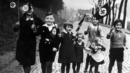 Propagandafoto für die Presse: Kinder mit Hakenkreuzfahnen.