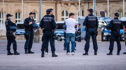 Polizisten bei einer Personenkontrolle auf dem Schlossplatz in Stuttgart.