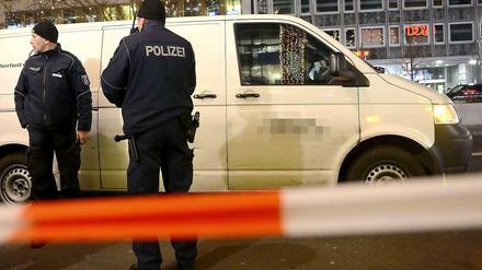 Tatort Taunetzienstraße. Polizisten stehen am 30.12.2013 vor dem überfallenen Geldtransporter.