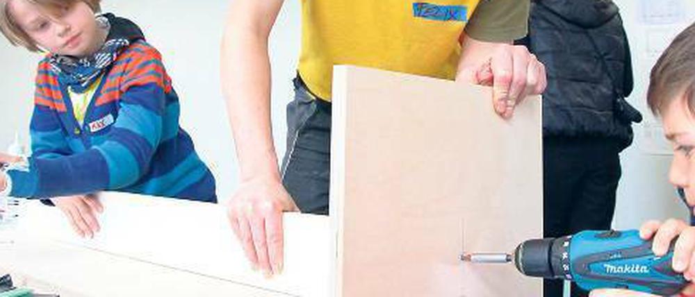 Die Steglitzer Grundschüler schrauben einen Tisch für ihr neues Klassenzimmer zusammen.