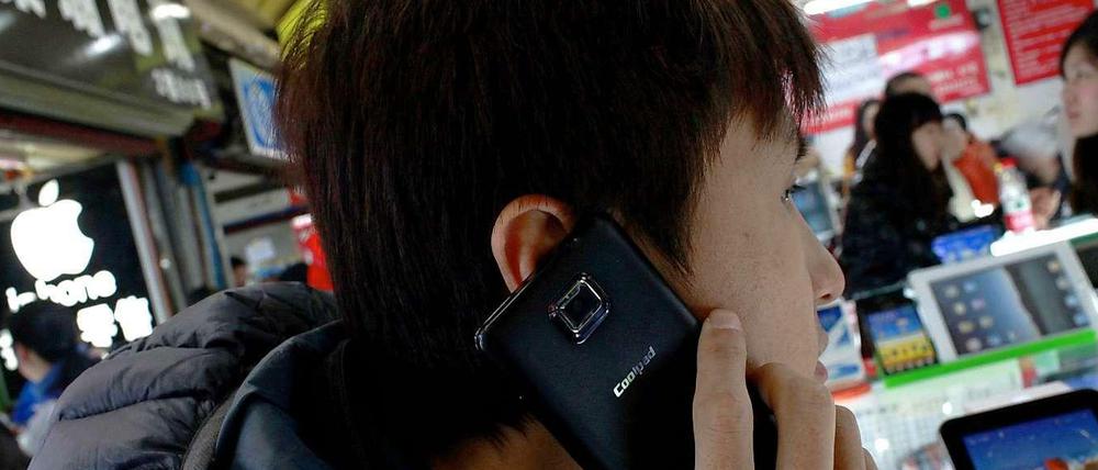 Immer schneller prasseln neue Geräte auf den Markt. Dieser Mann testet ein Coolpad 7290 auf einem Markt in Shanghai.