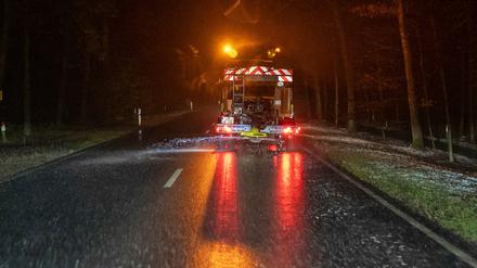 Ein Winterdienstfahrzeug streut eine Bundesstraße.