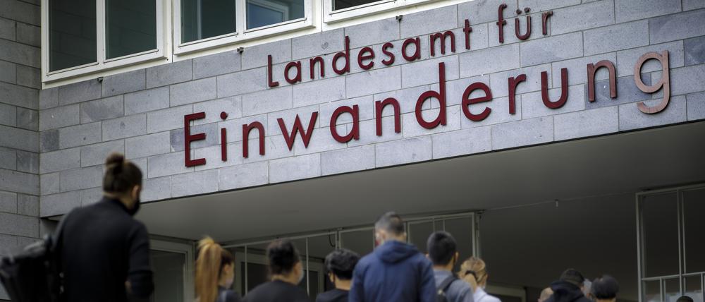 Wartende Menschen stehen vor dem Landesamt fuer Einwanderung in Berlin