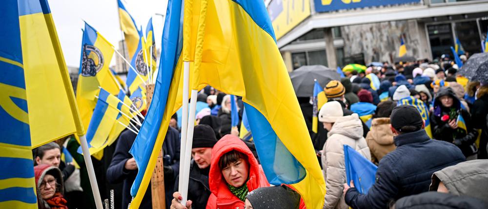 Teilnehmer einer Demonstration unter dem Motto „Wir werden nie vergessen“ stehen an der Karl-Marx-Allee vor dem Cafe Moskau, das für ein paar Tage in Cafe Kyiv (Kiew) umbenannt wurde.