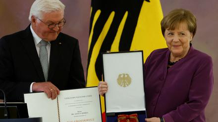 Frank-Walter Steinmeier überreicht den Verdienstorden an ehemalige Kanzlerin Angela Merkel.