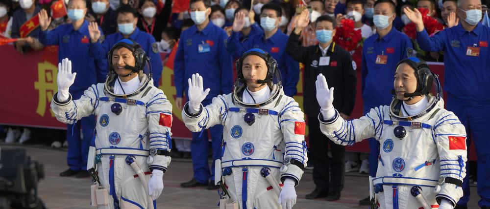 Die chinesischen Astronauten der Shenzhou-16-Mission, Gui Haichao (l-r), Zhu Yangzhu und Jing Haipeng, winken bei einer Abschiedszeremonie vor ihrer bemannten Weltraummission im Jiuquan Satellite Launch Center.