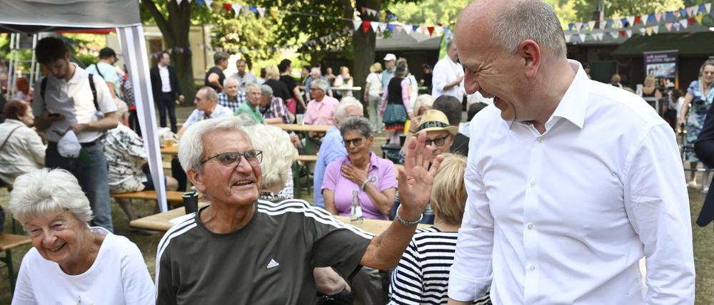 Kai Wegner (CDU), Berlins Regierender Bürgermeister, unterhält sich auf dem Sommerfest anlässlich des bundesweiten Tags des Gartens in der Dauerkleingartenanlage Rehberge im Berliner Stadtteil Wedding.