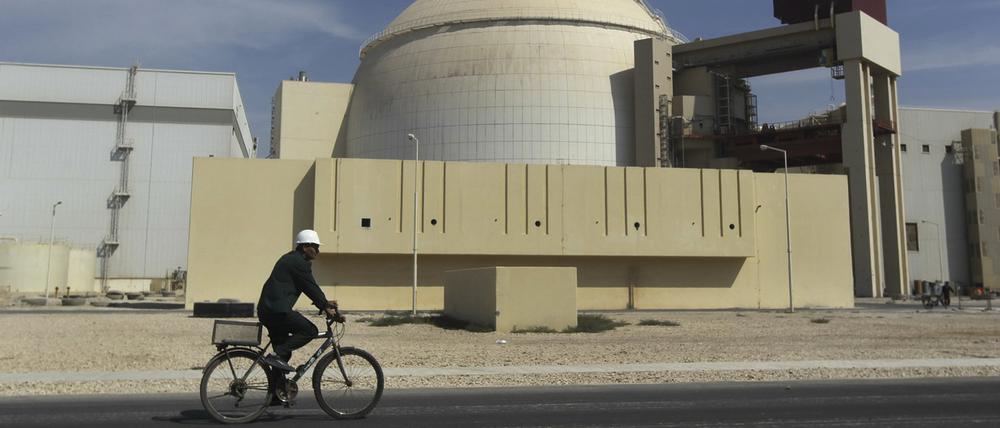  Ein Arbeiter fährt mit seinem Fahrrad vor dem Reaktorgebäude am Atomkraftwerk Buschehr. 