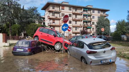 04.11.2023, Italien, Campi Bisenzio: Von den Wassermassen eines Unwetters übereinandergetürmt liegen Autos in den immer noch überfluteten Straßen. 