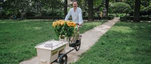 Die Urne sichtbar platziert, das Lastenrad mit Blumen geschmückt: Bestatter Eric Wrede mit seinem Lastenrad in Berlin.