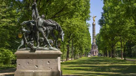 Im Tiergarten steht die Skulptur „Fuchsjagd“ mit Kriegsspuren, im Hintergrund die Siegessäule. 