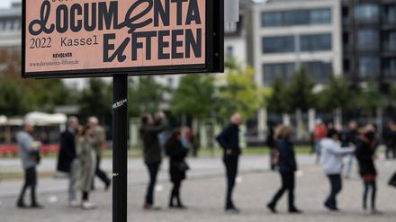 Schlange stehen für die Documenta fifteen: Besucher stehen hinter einem Veranstaltungsplakat am Eingang zum Museum Fridericianum an.