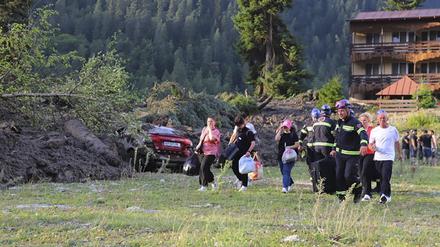 Menschen werden nach einem Erdrutsch in der Nähe von Schowi aus einem Ferienort evakuiert. Infolge eines Erdrutsches sind in einem Ferienort in Georgien im Kaukasusgebirge offiziellen Angaben zufolge mindestens elf Menschen ums Leben gekommen. 
