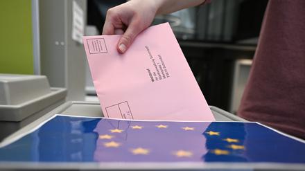 Ein Wahlbrief mit einem Stimmzettel für die Europawahl wird im Rathaus in einem Wahllokal für die Briefwahl in eine Wahlurne gesteckt.