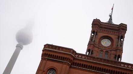 Der Fernsehturm steht am frühen Morgen hinter dem Roten Rathaus im Nebel.