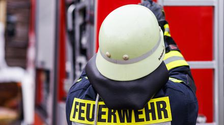 Ein Feuerwehrmann holt während einer Einsatzübung eine Leiter vom Dach eines Einsatzfahrzeugs