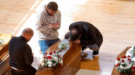 Trauernde beten in der Sporthalle von Crotone an den Särgen ihrer Angehörigen.