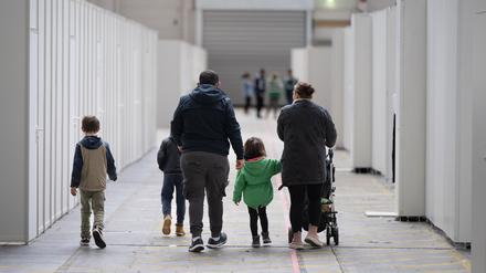 Eine Flüchtlingsfamilie geht durch die zu einer Massenunterkunft umfunktionierten Messehalle in Frankfurt. In der Halle sind seit einigen Wochen mehrere hundert Migranten und Asylsuchende aus unterschiedlichen Herkunftsländern untergebracht. 