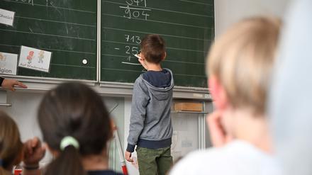 Schüler einer Grundschule lösen in einem Klassenzimmer Mathematikaufgaben. 