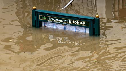 Ein Schild mit der Speisekarte eines Restaurants steht im Hochwasser der Donau.