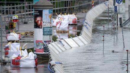 Helfer bauen Hochwasserstege und Schutzwände am Donauufer auf.