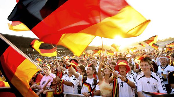 Deutsche Fans schwenken ihre Landesfahnen bei der WM 2006 beim Public Viewing in der Glück Auf Kampfbahn in Gelsenkirchen.