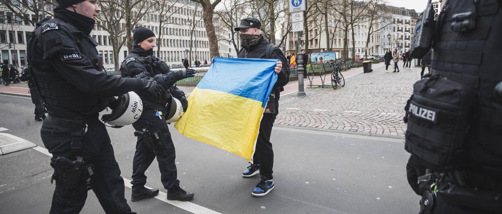 Bei einer pro-russischen Demo diskutiert ein Unterstützer der Ukraine mit Polizisten in Köln im April 2024.