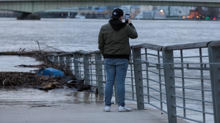 Hochwasser-Tourist fotografieren mit ihren Handys die Flut in Köln im Februar 2021.