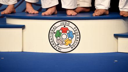 Symbolbild. Die Füße der Judoka in der Gewichtsklasse der Frauen über 78kg sind während der Siegerehrung auf dem Podest mit dem Logo der International Judo Federation zu sehen.