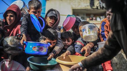 Rafah im Gazastreifen: Palästinensische Kinder erhalten in einer Wohltätigkeitsküche zubereitete Lebensmittel.