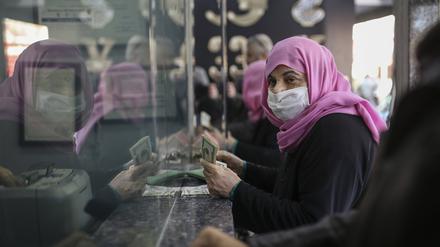 Eine Frau hält US-Dollarnoten in der Hand, während sie in einer Wechselstube türkische Lira wechselt.