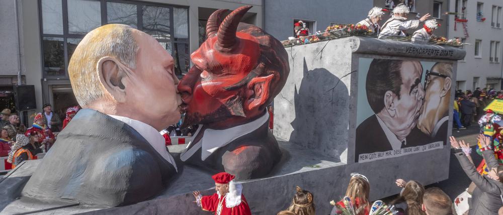 Die Koelner Persiflagewagen nehmen das Weltgeschehen satirisch aufs Korn. Sie zeigen etwa den russischen Praesidenten Wladimir Putin bei einem Kuss mit dem Teufel Foto.